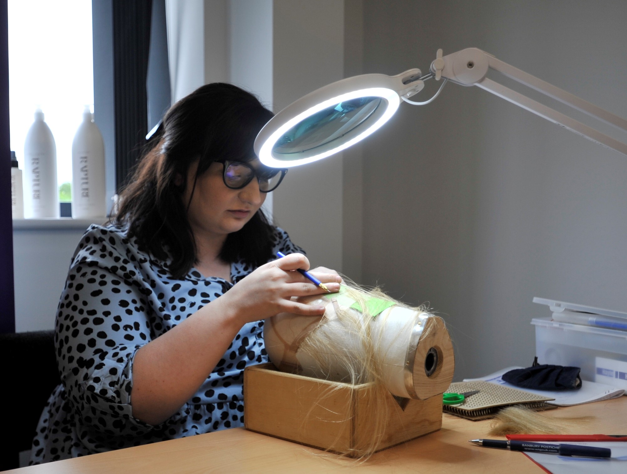 A wig knotter undergoes training at Banbury Postiche in Oxfordshire.