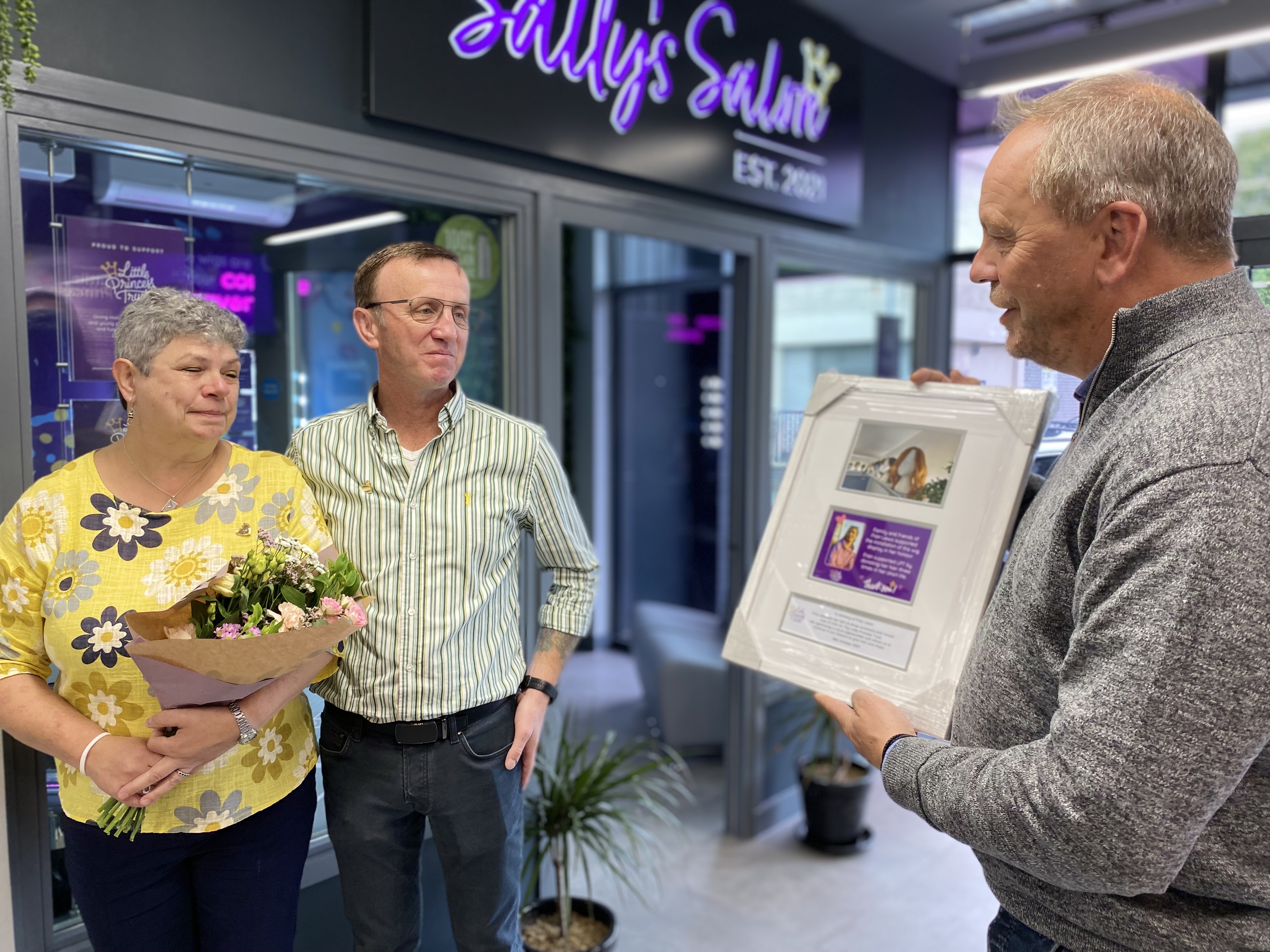 Phil Brace, from The Little Princess Trust, presents Fran's parents with a gift in recognition of their daughter's incredible support for our charity.
