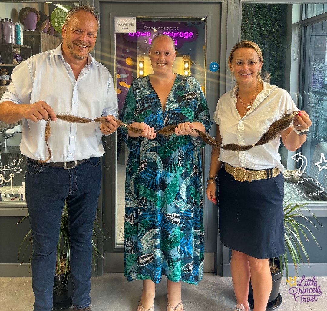 Ruth Tripp hands over her record hair donation to Phil Brace and Wendy Tarplee-Morris.